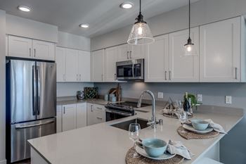 All Lux Apartments kitchens include stainless steel appliances including overhead venting microwave, dishwasher, double-door refrigerator with ice maker, and flat-top, electric stove and oven